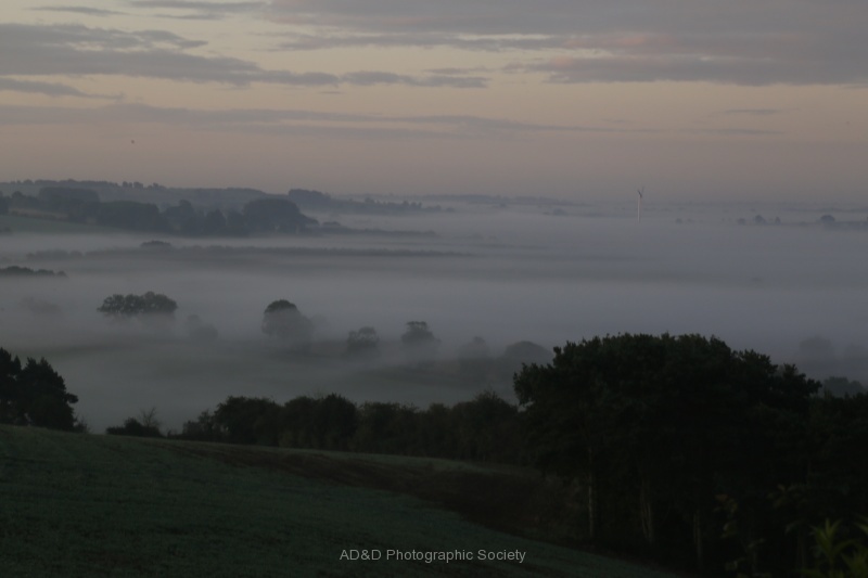 Daybreak with early morning mist tinged with a lit